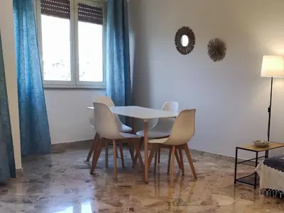 a dining room with a table and four chairs at Amunì rooms and suite LT in Palermo