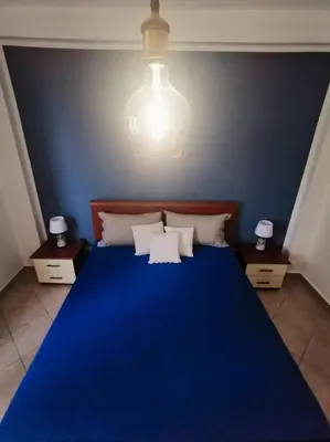 a bedroom with a blue bed with a blue wall at L'oasi nello Zingaro in Scopello