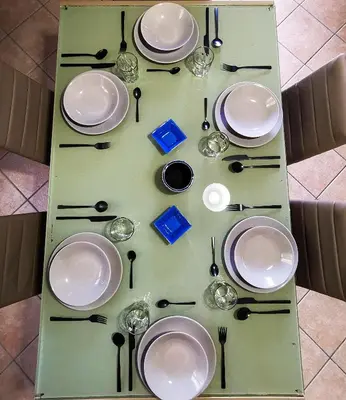a table with plates and utensils on it at L'oasi nello Zingaro in Scopello