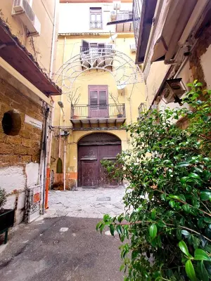an alley with a building with a large door at Guest House Palermo Massimo 23 in Palermo