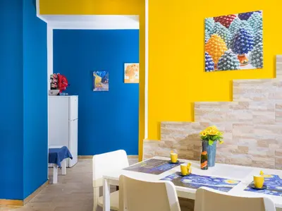 a dining room with a blue and yellow wall at Palermo Centro - I Pastelli di Van Gogh in Palermo