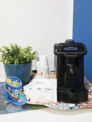 a coffee maker sitting on a table next to a plant at Palermo Centro - I Pastelli di Van Gogh in Palermo