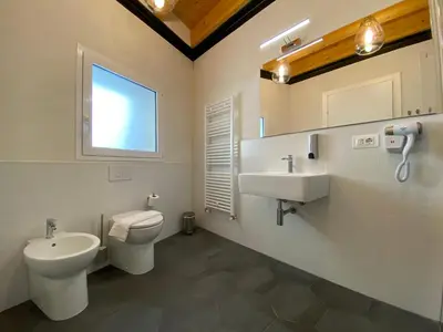 a bathroom with a toilet and a sink and a mirror at B&B ALIVA in Alcamo