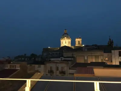 a view of a building with a clock tower at night at B&B ALIVA in Alcamo