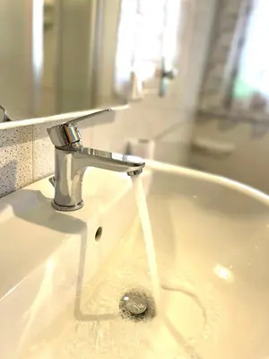 a sink with water coming out of a faucet at B&B La CYCAS in San Vito lo Capo