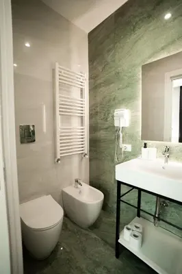 a bathroom with a sink and a toilet and a mirror at Borghi di Belmonte in Palermo
