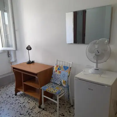 a room with a desk and a chair and a fan at Desire'- Le Caprice in Palermo
