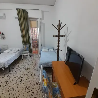 a bedroom with a bed and a tv and a table at Desire'- Le Caprice in Palermo