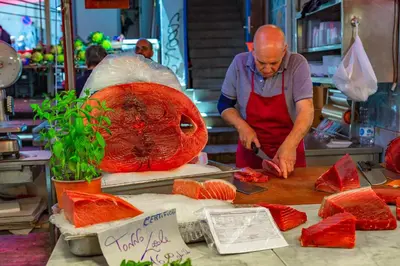 a man cutting up food on a cutting board at La casa di Dante in Palermo