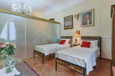 a bedroom with two beds with white sheets and red pillows at La casa di Dante in Palermo