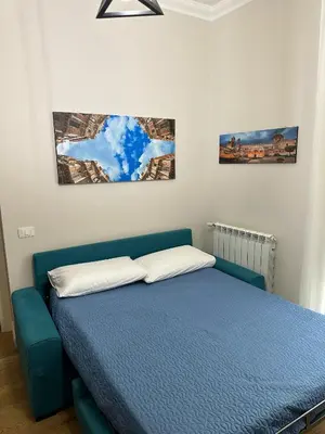 a bedroom with a blue bed and two pictures on the wall at Luxury Apartament's Celso in Palermo