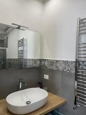 a bathroom with a white sink and a mirror at Luxury Apartament's Celso in Palermo