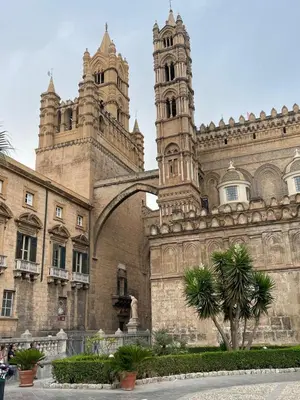 a building with two towers and a palm tree in front at Luxury Apartament's Celso in Palermo