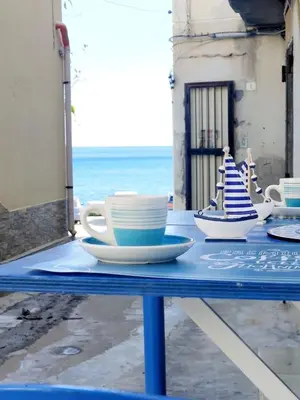 a blue table with cups and saucers on it at Bleu bijou apartment in Palermo