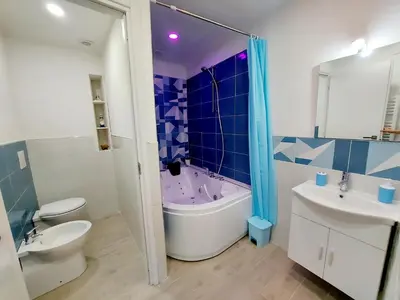 a kitchen with a table and blue chairs in a kitchen at Bleu bijou apartment in Palermo
