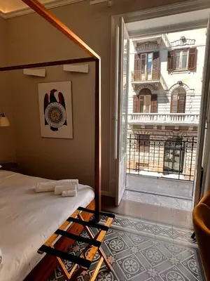 a hotel room with a bed with a backpack on it at B&B TIVÌTTI in Palermo