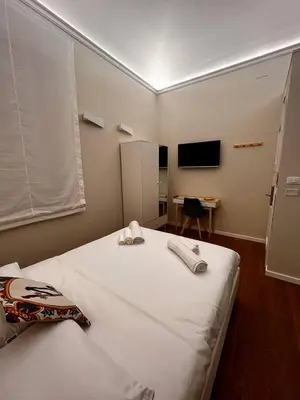 a bedroom with a large white bed with a desk at B&B TIVÌTTI in Palermo