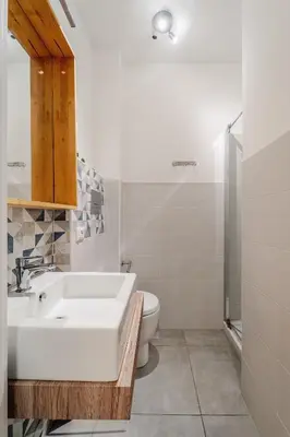 a white bathroom with a sink and a toilet at Tarzanà 11 apartment - Cala di Palermo in Palermo