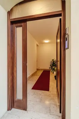 an open door into a hallway with a red rug at Tarzanà 11 apartment - Cala di Palermo in Palermo