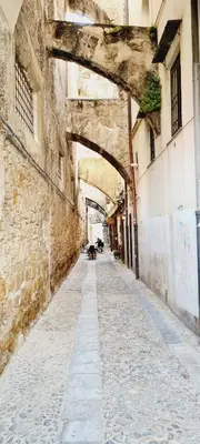 an alley in an old building with an archway at Tarzanà 11 apartment - Cala di Palermo in Palermo