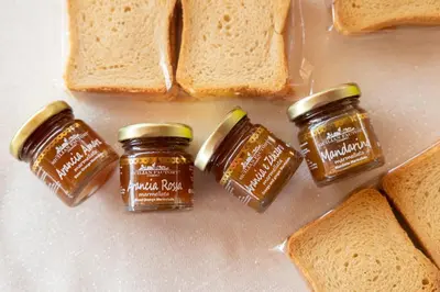 two jars of honey next to slices of bread at La Corte del Sole in Calatafimi