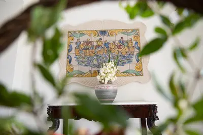 a vase of flowers on a table with a picture at La Corte del Sole in Calatafimi