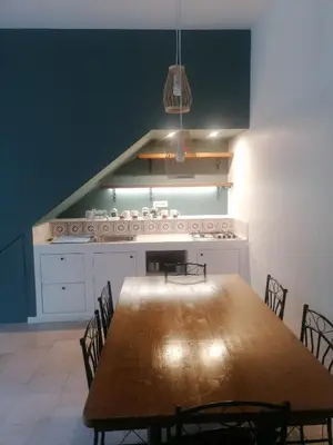 a dining room with a large wooden table and chairs at La casa nel Borgo in Scopello