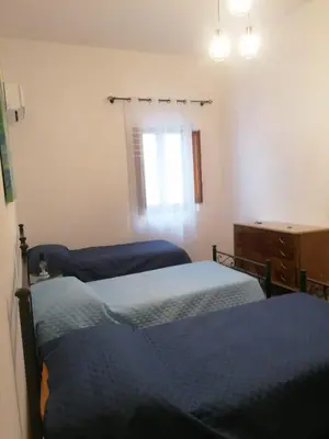 a bedroom with two beds and a dresser and a window at La casa nel Borgo in Scopello