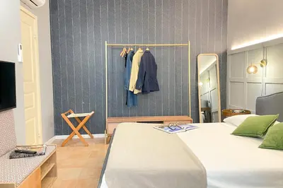 a bedroom with a bed and a tv and a mirror at Il Mare in una Stanza by DomuSicily in Mondello