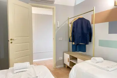a dressing room with two beds and a mirror at Il Mare in una Stanza by DomuSicily in Mondello