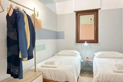 a small room with two beds and a mirror at Il Mare in una Stanza by DomuSicily in Mondello