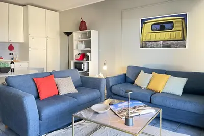 a living room with a blue couch and a table at Vacanze al Mare by DomuSicily in Mondello