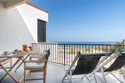 a balcony with a table and chairs and the ocean at Vacanze al Mare by DomuSicily in Mondello