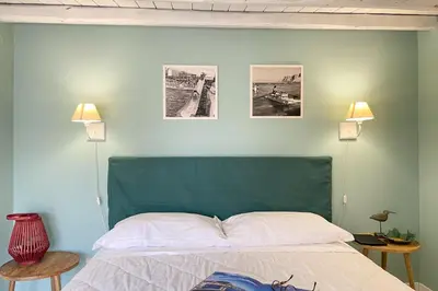 a bedroom with a bed with two pictures on the wall at Mondello in Terrazza by DomuSicily in Mondello