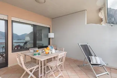 a table and chairs in a room with a window at Mondello in Terrazza by DomuSicily in Mondello
