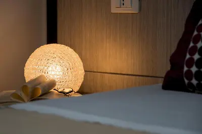 a lamp sitting on a bed with a book at B&B A casa di Aurora rooms in San Vito lo Capo