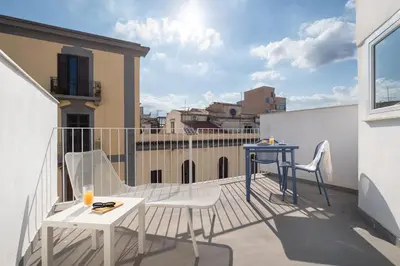 a balcony with a table and chairs on a building at Attico 37 - Suite con terrazza privata e cucina in Palermo