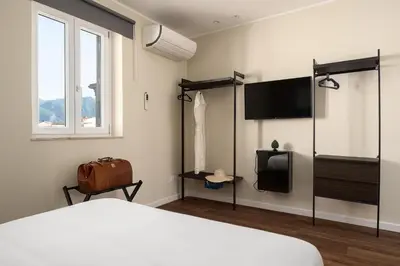 a hotel room with a bed and a television at Attico 37 - Suite con terrazza privata e cucina in Palermo