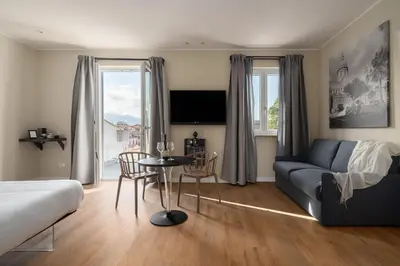 a living room with a couch and a table with chairs at Attico 37 - Suite con terrazza privata e cucina in Palermo