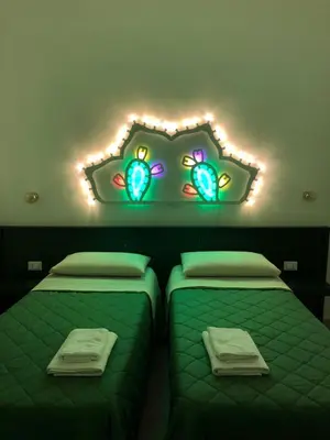 two beds in a room with lights on the wall at Casa Paradiso in Castronuovo di Sicilia