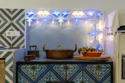 a counter with a pot on a table with blue lights at Casa Paradiso in Castronuovo di Sicilia