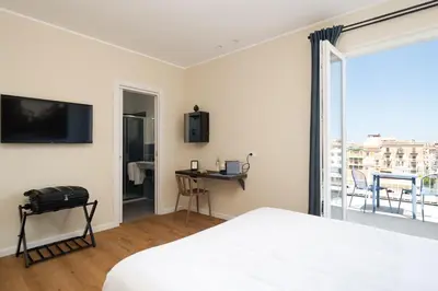 a white bedroom with a bed and a balcony at Attico 37 - Comfort room con terrazza privata in Palermo
