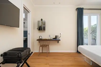 a bedroom with a bed and a table and a chair at Attico 37 - Comfort room con terrazza privata in Palermo