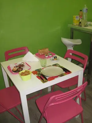 a table with a plate of food and pink chairs at Bed & Breakfast Amari 58 in Palermo