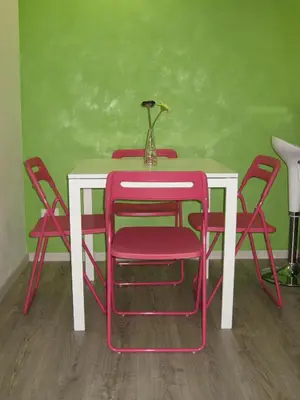 a table with red chairs and a white table with a vase on it at Bed & Breakfast Amari 58 in Palermo