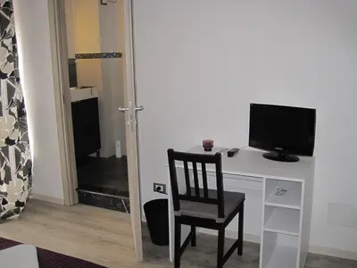 a room with a desk with a television and a chair at Bed & Breakfast Amari 58 in Palermo