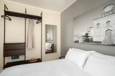 a bedroom with a white bed and a mirror at Attico 37 - Comfort room con terrazza privata in Palermo