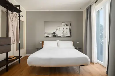 a bedroom with a large bed and a large window at Attico 37 - Comfort room con terrazza privata in Palermo