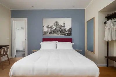 a large white bed in a room with blue walls at Attico 37 - Comfort room con terrazza privata in Palermo