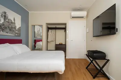 a bedroom with a white bed and a flat screen tv at Attico 37 - Comfort room con terrazza privata in Palermo